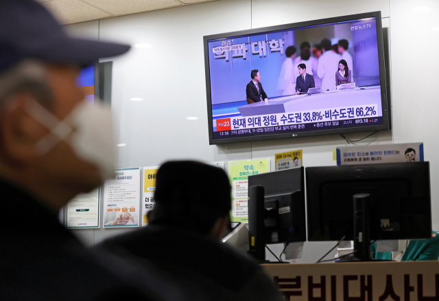 20일 오후 광주 동구 전남대학교병원에서 한 시민이 정부의 전국 의과대학별 정원 배정 결과 발표를 바라보고 있다. 광주=연합뉴스