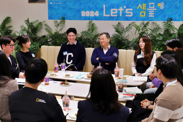 김상현(뒷줄 왼쪽 네번째) 롯데 유통군 총괄대표 부회장이 자체 브랜드(PB) 현장 직원들을 만나 소통하고 있다. 사진 제공=롯데쇼핑