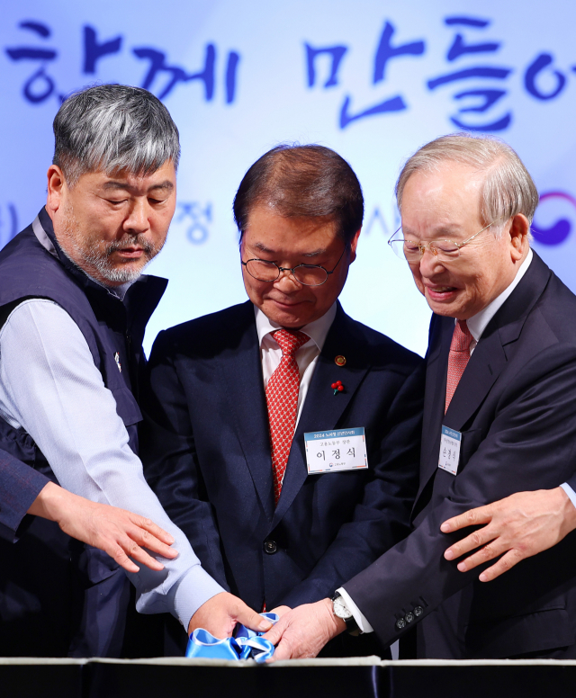 1월 5일 오후 서울 중구 서울중앙우체국에서 열린 노사정 신년인사회에서 김동명 (왼쪽부터) 한국노총 위원장, 이정식 고용노동부 장관, 손경식 한국경영자총협회장이 축하 떡을 자르고 있다. 연합뉴스