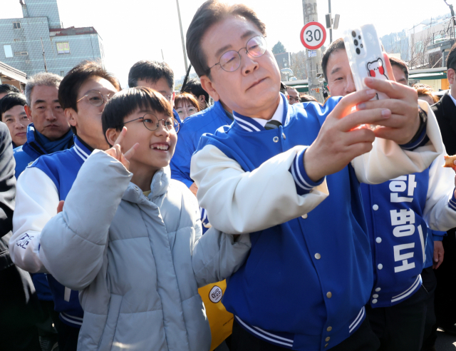 이재명 더불어민주당 대표와 어린이가 21일 오후 전북 군산시 옛 도심에서 셀카를 찍고 있다. 연합뉴스