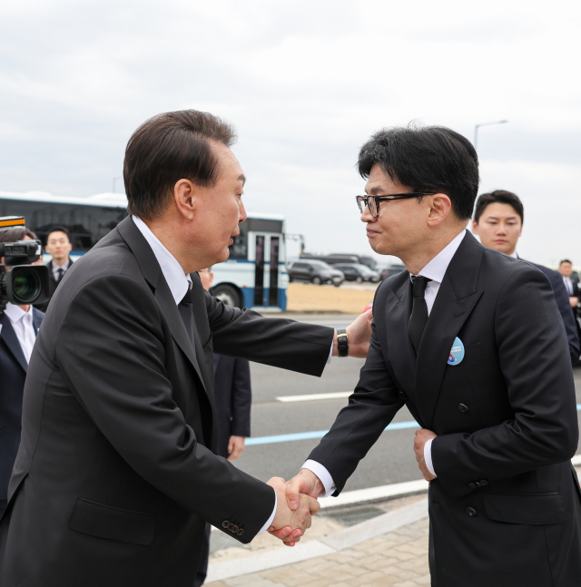 윤석열 대통령이 22일 경기도 평택시의 해군 제2함대사령부에서 거행된 ‘제9회 서해수호의 날’ 기념식을 마친 뒤 한동훈 국민의힘 비상대책위원장의 어깨를 두드리며 악수하고 있다. 연합뉴스