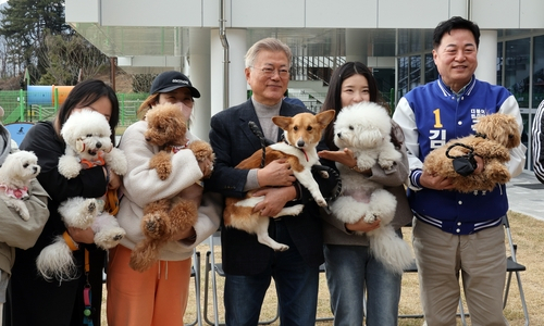 문재인 전 대통령이 22일 오후 경남 양산시 유기동물보호소와 반려동물지원센터를 찾아 유기견을 돌보고 간담회를 가진 후 반려견과 함께 센터를 찾은 시민 등과 반갑게 기념촬영을 하고 있다. 연합뉴스