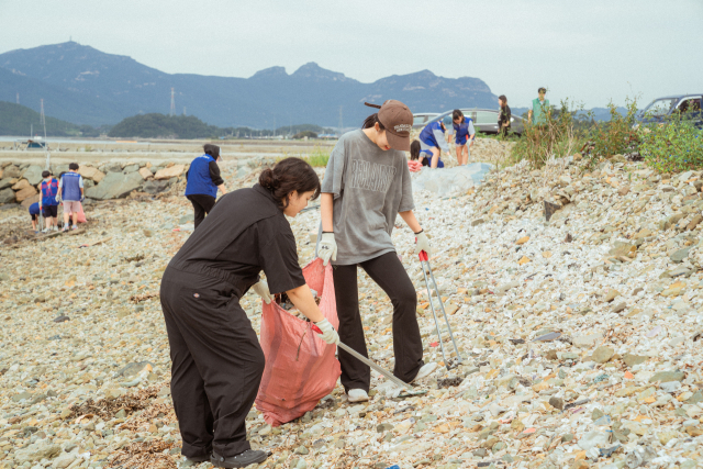 지난해 8월 김유솔(왼쪽) 이장이 마을 주민들과 동네에 버려진 쓰레기를 줍고 있다.