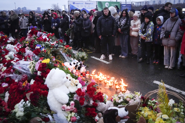 23일(현지 시간) 러시아 모스크바 서쪽의 크로커스시청 옆에 시민들이 모여 추모하고 있다. 22일 크로커스시청 내 공연장에 7000명의 관람객들이 몰린 가운데 이들을 대상으로 한 테러가 발생해 수많은 사상자가 발생했다. 러시아 수사 기관은 모스크바 공연장 테러로 133명이 사망했다고 밝혔다.AP연합뉴스