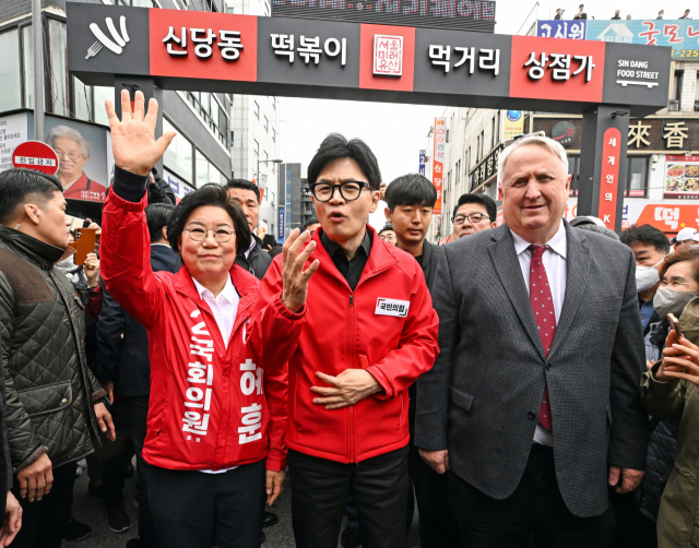 한동훈(앞줄 가운데) 국민의힘 총괄선거대책위원장 겸 비상대책위원장이 25일 서울 신당동 떡볶이타운 거리에서 인요한(〃 오른쪽) 국민의미래 선대위원장, 이혜훈(〃 왼쪽) 중·성동을 국민의힘 후보와 함께 시민들에게 인사하고 있다. 연합뉴스