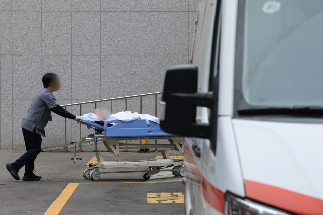의료진이 25일 서울 시내 2차 병원에서 환자를 이송하고 있다. 연합뉴스