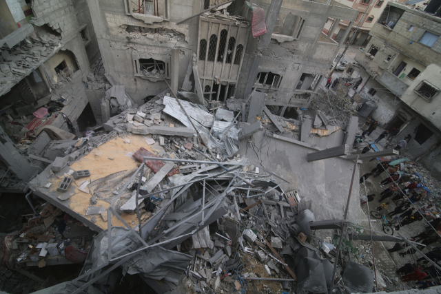 팔레스타인인들이 가자지구 남부 도시 라파에 대한 이스라엘의 공습 이후 건물 잔해를 확인하고 있다. 신화연합뉴스