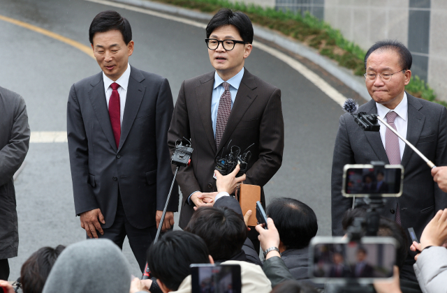 한동훈(가운데)국민의힘 비상대책위원장이 26일 대구 달성군 박근혜 전 대통령 사저 앞에서 박 전 대통령 예방을 마친 후 기자들의 질문에 답하고 있다. 한 위원장 왼쪽은 박 전 대통령의 최측근이자 대구 달성갑에 국민의힘 후보로 출마한 유영하 변호사. 연합뉴스