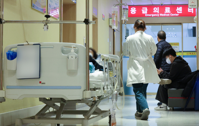 전공의 집단행동이 한 달간 이어지고 있는 이달 19일 오전 서울 시내 한 대형병원에서 한 의료 관계자가 응급의료센터로 이동하고 있다. 연합뉴스
