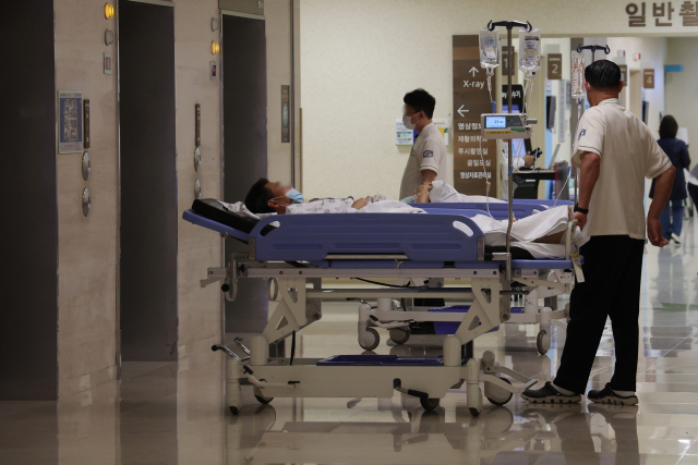 의료대란이 장기화되고 있는 가운데 28일 서울의 한 대학병원에서 입원실 침대에 누운 환자가 엘리베이터를 기다리고 있다.연합뉴스