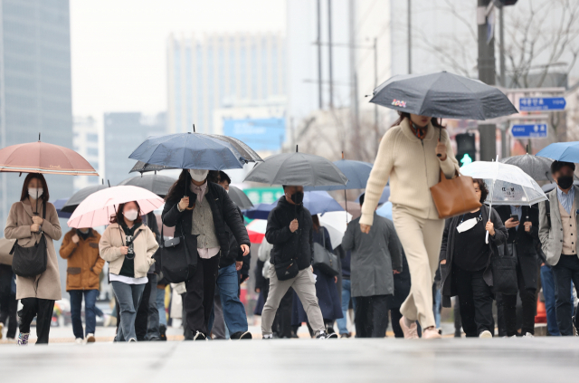 28일 오전 비가 내리는 서울 광화문광장에서 시민들이 우산을 쓴 채 걸어가고 있다. 연합뉴스