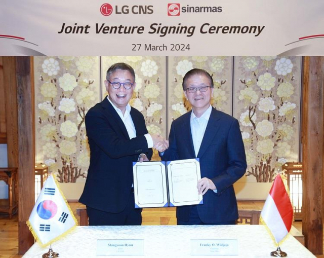 현신균(왼쪽) LG CNS 대표가 프랭키 우스만 위자야 시나르마스 회장과 합작투자 계약을 체결한 뒤 계약서를 들어 보이고 있다. 사진 제공=LG CNS