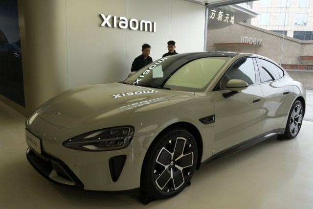 3월 26일 중국 베이징의 샤오미 매장에 전시된 세단 전기차 신형 모델 SU7을 방문객들이 살펴보고 있다. AP연합뉴스