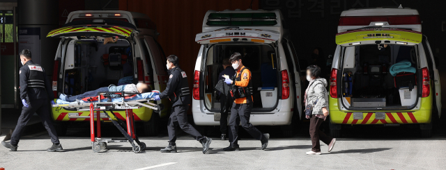 전공의 집단행동이 이어지고 있는 29일 대구 한 대학병원 응급실 앞에서 119구급대원이 환자를 옮기고 있다. 연합뉴스