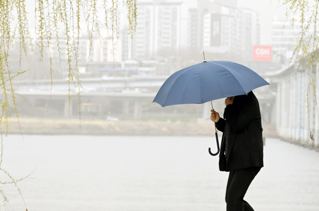 29일 서울 반포동 한강공원에서 시민이 우산을 쓰고 발걸음을 재촉하고 있다. 권욱 기자