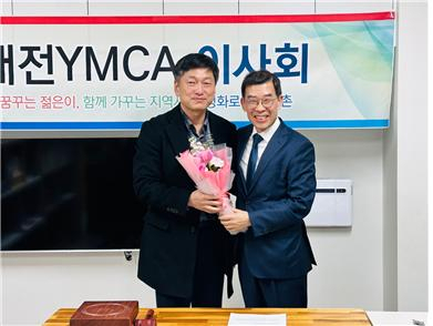 대전YMCA 제34대 정용이(왼쪽) 이사장이 전임 김찬훈(오른쪽) 이사장으로 축하의 꽃다발을 받고 기념촬영을 하고 있다. 사진제공=대전YMCA