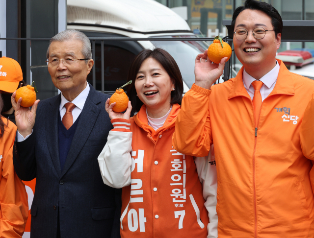 김종인 개혁신당 공관위원장과 천하람 선대위원장, 허은아 후보 등이 28일 영등포역 광장에서 중앙당 선대위 출정식 중 오렌지를 들고 기념촬영을 하고 있다. 연합뉴스