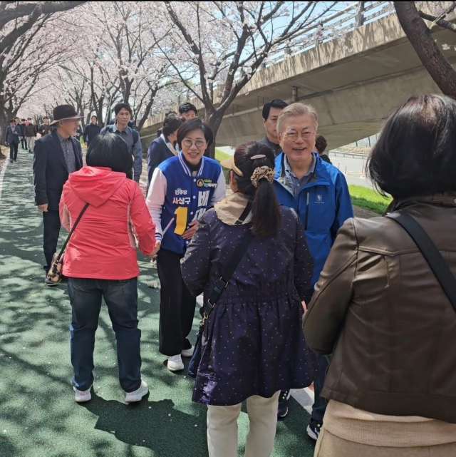 문재인 전 대통령이 1일 부산 사상구 괘법동에 있는 벚꽃길을 걸으며 시민들과 인사를 나누고 있다. 연합뉴스