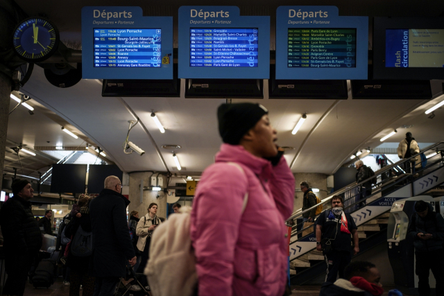 지난 2월 프랑스 리옹 기차역에서 SNCF 관제사들의 파업으로 일정에 차질을 빚은 탑승객들이 운행 시간을 알리는 전광판 앞을 지나고 있다./AP연합뉴스