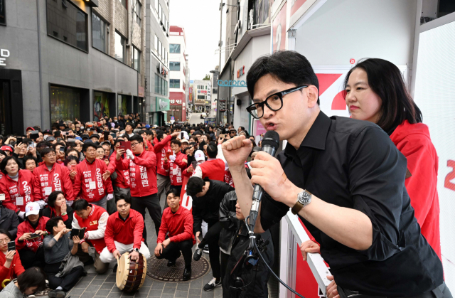 한동훈 '범죄자와 싸우는데 큰절' 왜 하나”…이재명, 시장 바닥서 큰절 