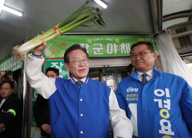 이재명 더불어민주당 대표가 27일 충북 제천시 동문시장에서 시민들을 향해 대파를 들어 보이고 있다. 연합뉴스