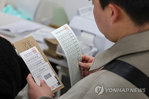 제22대 국회의원선거 사전투표 둘째날인 6일 서울 중구 명동주민센터에 마련된 사전투표소에서 한 유권자가 투표용지를 확인하고 있다. 연합뉴스