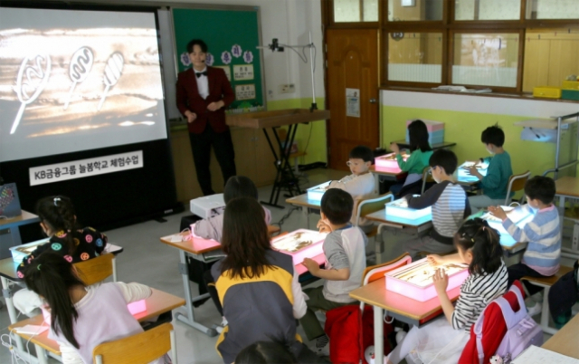 KB금융그룹은 이달 5일 경기도 성남시 분당구 수내초등학교에서 KB금융 직원이 함께하는 ‘늘봄학교 샌드아트 체험 수업’을 진행했다고 밝혔다. 사진제공=KB금융