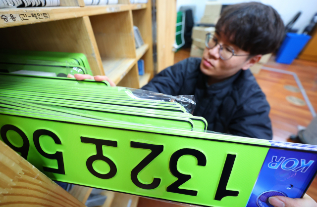 1월 2일 서울 송파구청에서 한 직원이 법인 승용차용 연두색 번호판을 정리하고 있다. 연합뉴스