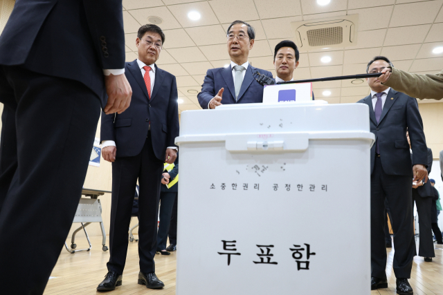 한덕수(가운데) 총리가 9일 서울 종로1.2.3.4가동 행정복지센터에 마련된 투표소를 찾아 준비 상황을 점검하고 있다. 연합뉴스