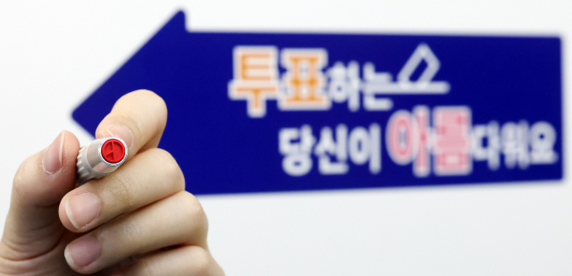 제22대 국회의원선거를 하루 앞둔 9일 오후 서울 영등포구 YDP미래평생학습관에 마련된 투표소에서 관계자가 기표용구를 들어보이고 있다. 연합뉴스