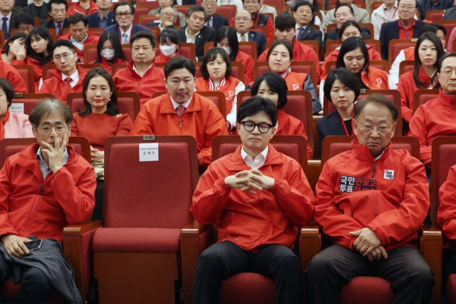 한동훈 국민의힘 총괄선대위원장과 김경율 선대위 부위원장(첫 줄 왼쪽) 등이 10일 서울 여의도 국회도서관에 마련된 제22대 국회의원선거 개표상황실에서 출구조사 결과를 시청하고 있다. 연합뉴스