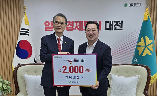 한남대학교 이승철(왼쪽) 총장이 이장우(오른쪽) 대전시장에게 ‘대전 0시 축제’ 협찬금을 기탁하고 있다. 사진제공=한남대