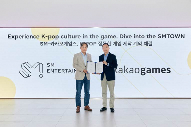 장철혁(왼쪽) SM엔터테인먼트 대표와 한상우 카카오게임즈 대표가 K-팝을 접목한 게임 제작 계약을 체결하고 기념촬영을 하고 있다. 사진 제공=카카오게임즈