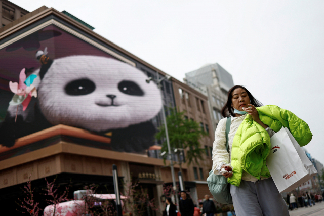 한 여성이 10일 중국 베이징의 한 쇼핑 거리를 걷고 있다. 로이터연합