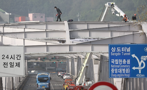신원불명의 남성이 17일 오전 서울 용산구 한강대교 아치 위에 올라가 소방대원들과 경찰이 현장에 출동해 있다. 연합뉴스