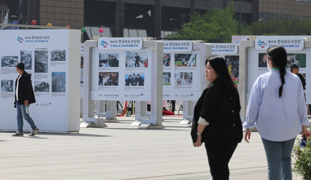 18일 시민들이 서울 광화문광장 놀이마당전시장에서 개막한 ‘제60회 한국보도사진전’을 관람하고 있다. 사진공동취재단