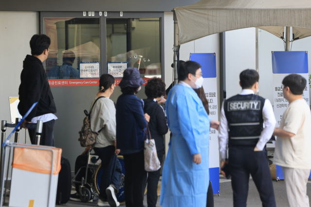 정부의 의대 증원 추진에 반발한 전공의들이 병원을 떠난지 60일째인 18일 서울 시내 한 대학병원 응급진료센터 앞에서 환자와 보호자가 대기하고 있다. 연합뉴스