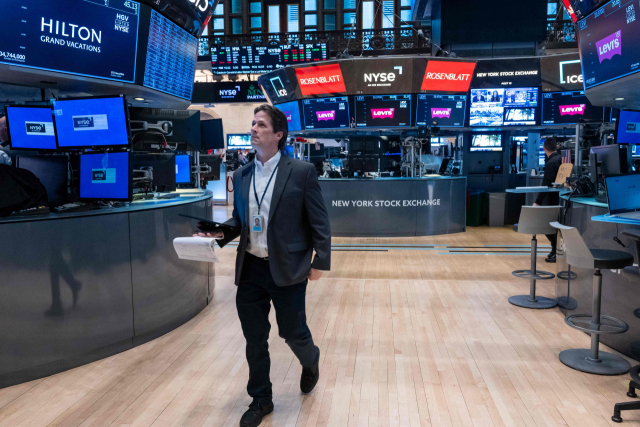 미국 뉴욕 맨해튼 뉴욕증권거래소(NYSE)에서 한 트레이더가 모니터를 바라보며 걸어가고 있다. AFP연합뉴스