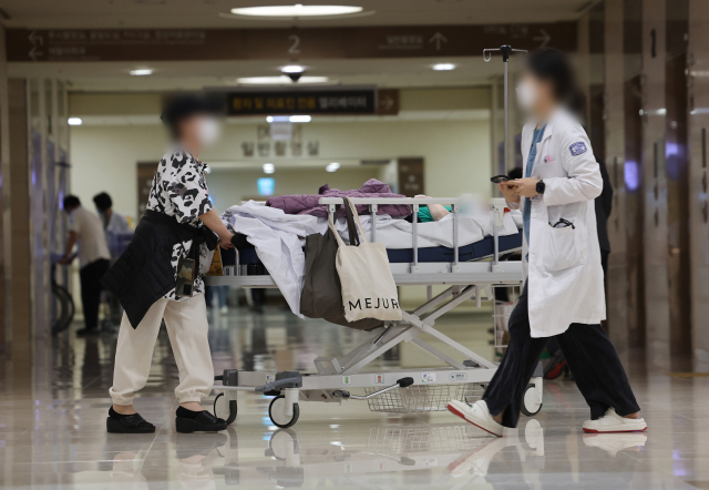 19일 서울 시내의 한 대학병원에서 의료 관계자와 환자들이 이동하고 있다. 연합뉴스