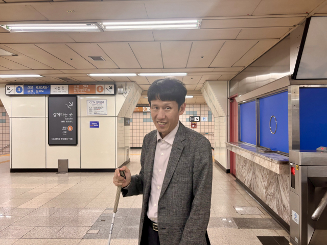 18일 삼각지역에서 박명수(47)씨가 지하철을 타고 국립장애인도서관으로 향하고 있다.장형임기자