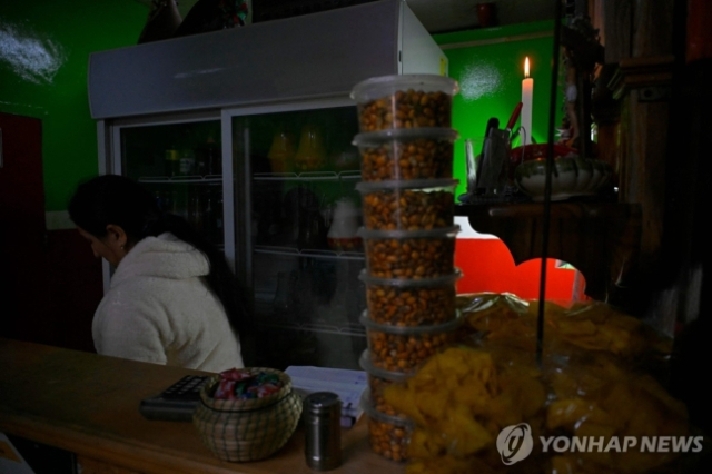 전력난으로 촛불을 밝히고 있는 가게의 모습. 사진=연합뉴스