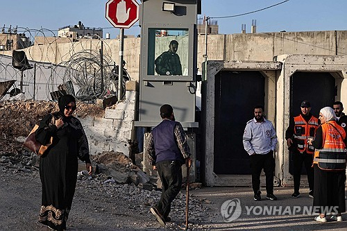 지난 5일(현지시간) 요르단강 서안 점령지역에 있는 이스라엘 검문소로 가는 팔레스타인 무슬림들을 이스라엘 군인이 지켜보고 있다.AFP연합뉴스