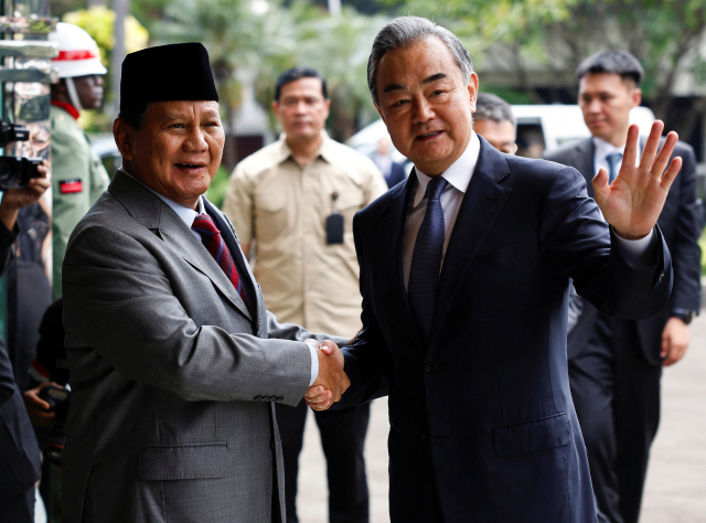 지난 18일 프라보워 수비안토(왼쪽) 인도네시아 대통령 당선인이 왕이 중국 외교부장과 만나 악수하고 있다. 연합뉴스