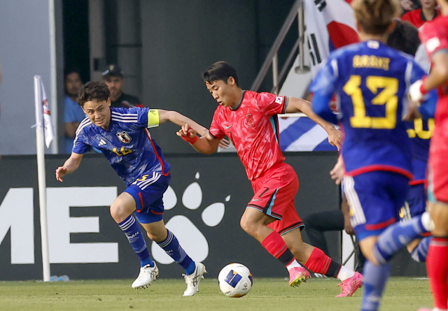 한국 23세 이하 축구 대표팀의 홍시후(왼쪽 두 번째)가 22일 아시안컵 조별리그 일본전에서 드리블을 하고 있다. 교도연합뉴스