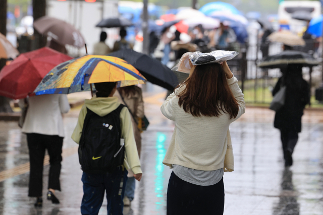 전국 곳곳에 비가 내린 지난 15일 서울 지하철 5호선 광화문역 인근 종로에서 시민들이 종종걸음으로 이동하고 있다. 연합뉴스