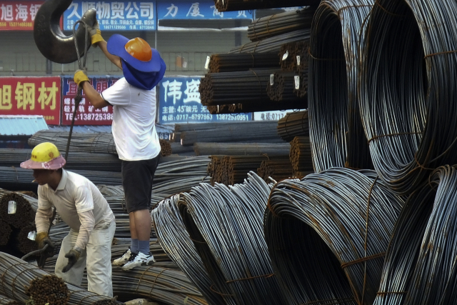 노동자들이 중국 중부 후베이성 이창의 한 철강 시장에서 철근을 싣고 있다. AP연합뉴스