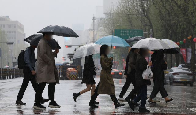 서울 종로구청입구 사거리에서 우산을 쓴 시민들이 횡단보도를 건너고 있다. 연합뉴스