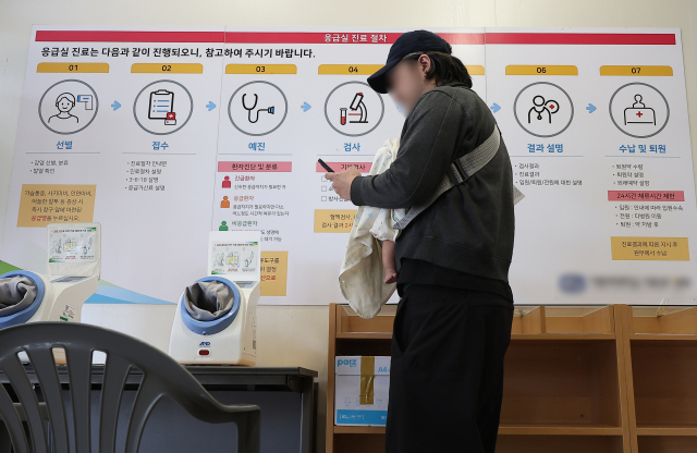 28일 서울 시내 한 대형병원 응급의료센터 대기실에서 한 내원객이 아이와 함께 진료를 기다리고 있다. 연합뉴스