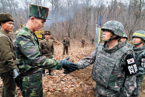2018년 11월 22일 도로연결 작업에 참여한 남북인원들이 군사분계선(MDL) 인근에서 인사하고 있다. 사진 제공=국방부