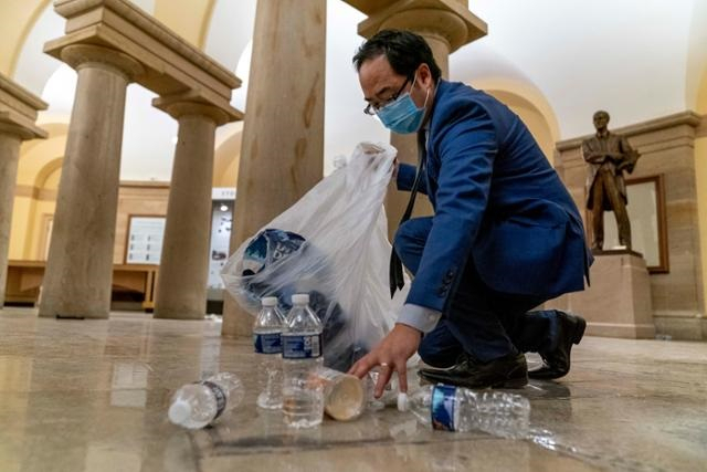 앤디 김 미 연방 하원의원이 2021년 1월 트럼프 대통령 지지자들이 난입한 뒤 아수라장이 된 미국 워싱턴DC 의회의사당에서 쓰레기를 치우고 있다. AP연합뉴스